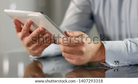 Man holding tablet in hands closeup reading news online, business application