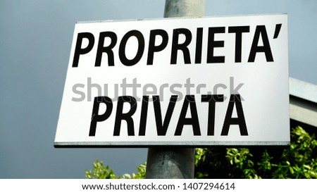 Signboard with the word PRIVATE PROPERTY in Italian as seen from below outside a building site in the city
