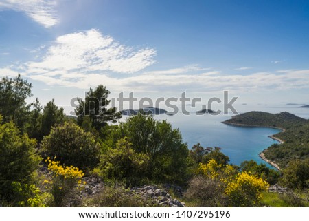 Razanj Croatia Europe. Nature and landscape photo of coastline at Adriatic Sea in Dalmatia. Beautiful outdoors on sunny spring day. Nice blue sky and green, yellow grass, trees and bushes.