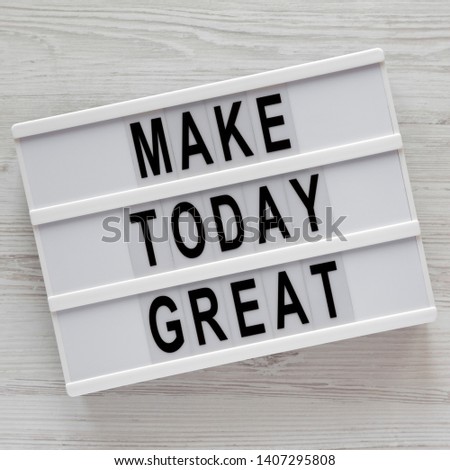 Modern board with 'Make today great' words on a white wooden table, top view. Overhead, from above. Flat lay. 