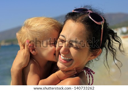 Baby kissing her happy mother