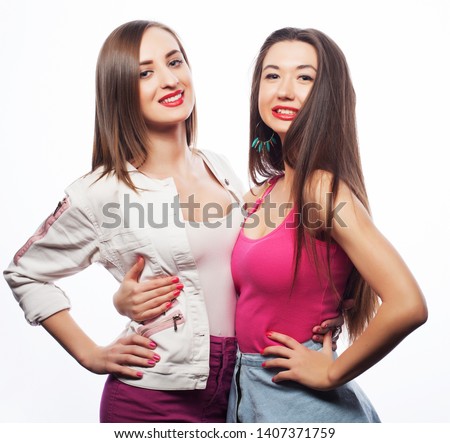 lifestyle and people concept: Two young girl friends standing together and having fun.