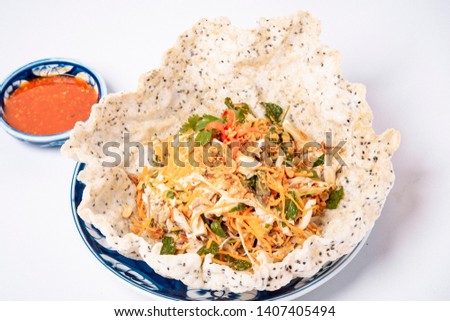 Chicken salad and vegetables on dry pancake on white background. Vietnamese traditional food.