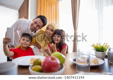 kids with mom and dad taking picture together while having breakfast