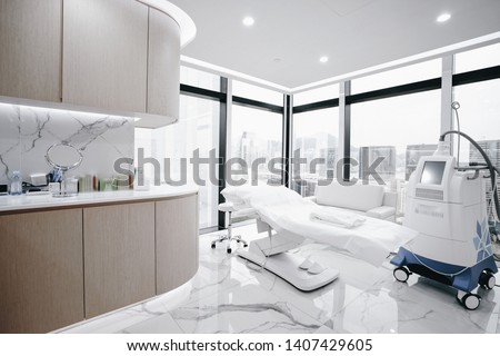 Hospital interior with operating surgery table, lamps and ultra modern devices, technology in modern clinic. Royalty-Free Stock Photo #1407429605