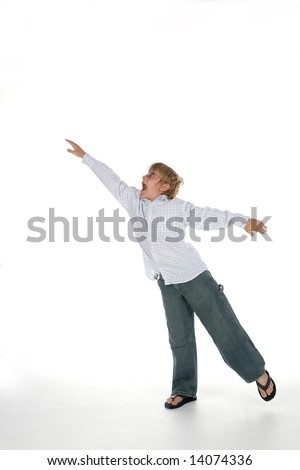 young boy with arms outstretched as if flying and balancing on one leg