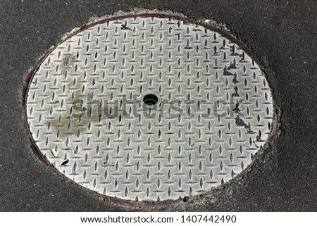 round steel man hole cover in tarmack asphalt