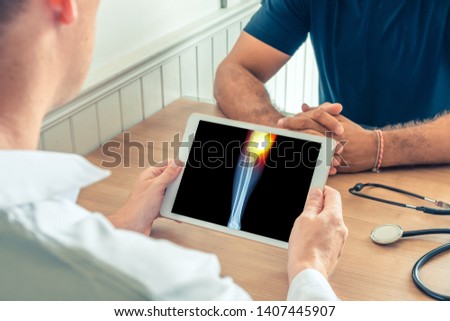 Doctor holding a digital tablet with x-ray of knee of the patient. Pain on the internal knee