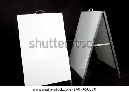 two blank a-frame signs with copy space on black background 