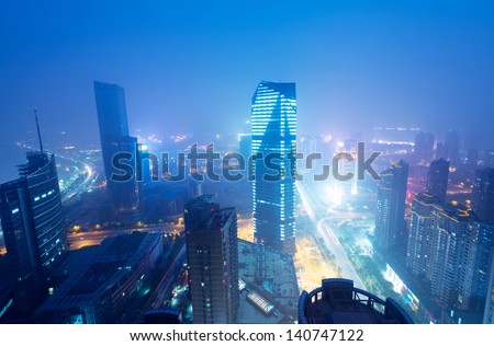 Bird view at Nanchang China. Skyscraper under construction in foreground. Fog, overcast sky and pollution. Bund (Nanchang) area
