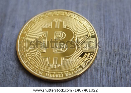 Golden coin with bitcoin symbol close up on wooden background. Electronic crypto currency and business concept.
