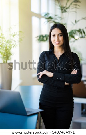 Confident businesswoman looking at camera in office.
