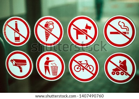 signs of prohibition of drinking alcohol, eating ice cream, dog walking, smoking, rollerblading and cycling on a glass surface; a sign to throw garbage in bins; video surveillance sign; yellow frames