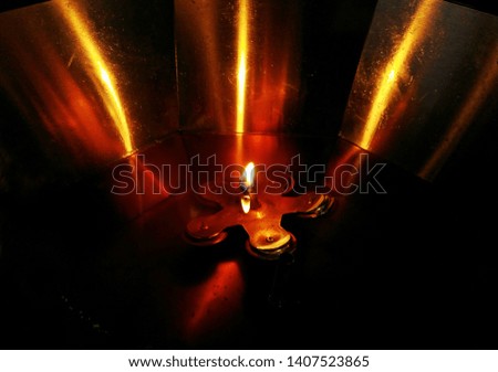 A little candle lits in a brass basin