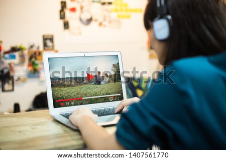 Woman Watching online video movie in living room Royalty-Free Stock Photo #1407561770