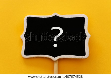 Chalkboard with question mark sign over yellow background