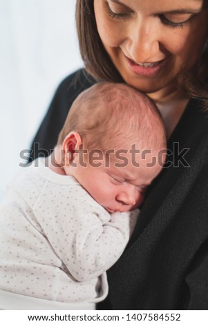 New mother sleeping her cute adorable newborn on his lap. Baby expresses calm and peace. Family, new life, childhood, beginning concept.