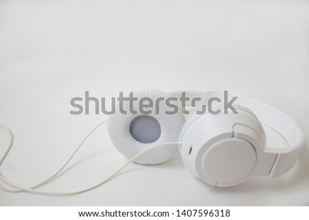 White headphones on a light background isolated
