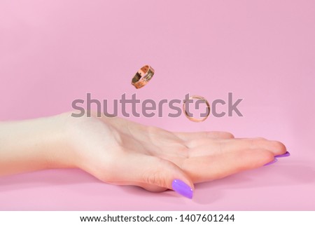 rings in hand on a pink background in flight. newlyweds wedding. couple creating a family. together forever. marriage bond marriage. girl palm