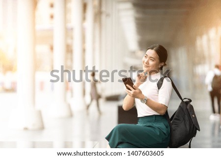 Happy woman using smart phone in the city