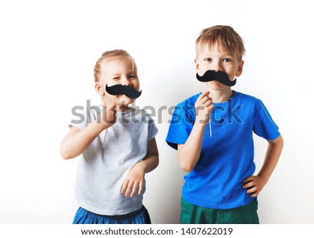 Fathers day concept, two little caucasian kids smiling with moustache on white background, copy space 