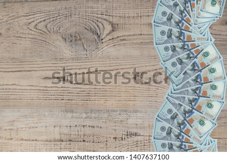 American paper dollar bills as part of the global financial and trading system. Frame of bills on wooden table. Top view
