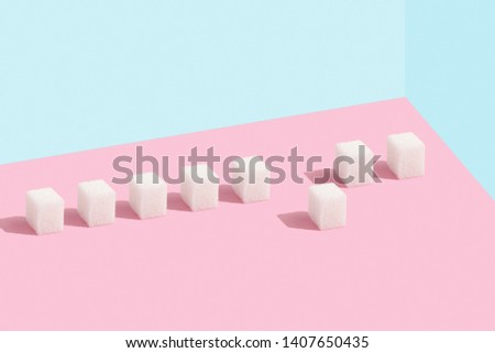 Sugar cubes in a row. One standing out from the crowd. Pastel colors. Minimal, pattern, Copy space.