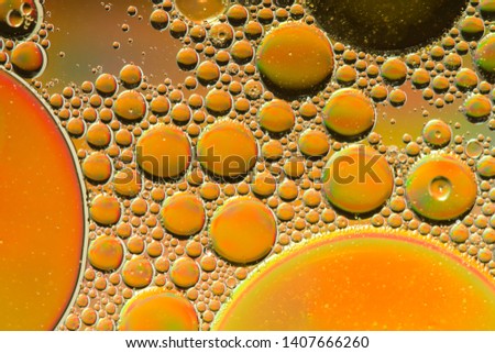 Gold psychedelic abstract formed by oil droplets floating on water