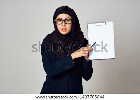 hijab woman with glasses holding a folder-tablet blank white place free                               