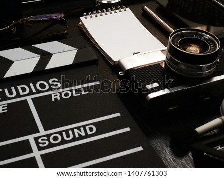 Cameras and photographic equipment slate film, glasses and wristwatch on the black background.