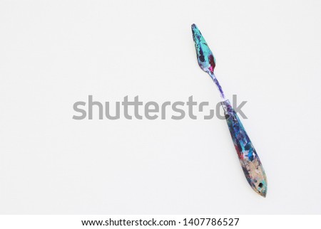 
palette knife in paint on white canvas Royalty-Free Stock Photo #1407786527