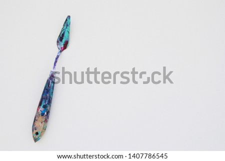
palette knife in paint on white canvas Royalty-Free Stock Photo #1407786545