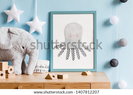 The modern scandinavian newborn baby room with mock up poster frame, wooden toys, blocks, elephant and accessories. Minimalistic and cozy interior with blue walls. Haniging cotton balls and stars