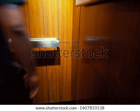 people hands moving inside a lift over a wooden wall. 