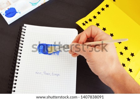 With a brush and blue paint, as well as punched out yellow paper stars, the flag of the EU was drawn on a block sheet - Concept for Europe and the unity in the EU to match the European elections