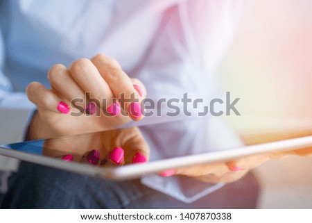 Woman using digital tablet computer, close-up photo with focus on finger