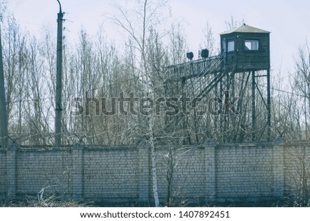 Watchtower at the fence with barbed wire. Soft focus