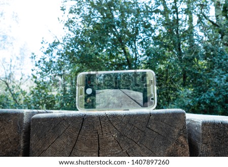 mobile phone on a wood table in a park 