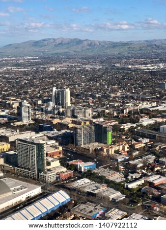 Scenic view of San Jose from the window of an airplane on a beautiful day. Downtown buildings and mountains are visible