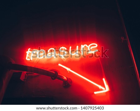 Treasure red neon sign with arrow pointing the lower right corner