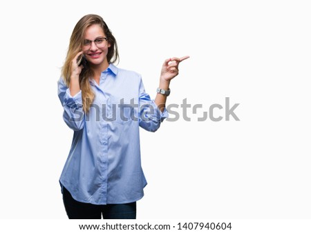 Young beautiful blonde business woman calling using smartphone over isolated background very happy pointing with hand and finger to the side