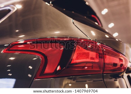 Close up of rear lights detail of modern luxury car with projector lens for low and high beam. Front view of sport crossover vehicle head lamp. Concept of car detailing and light technology background