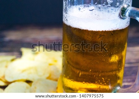 Fresh cold beer in a sweaty glass on a blurred background close-up