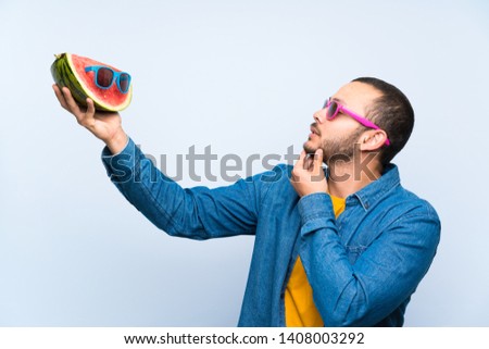 Colombian man holding a watermelon with sunglasses