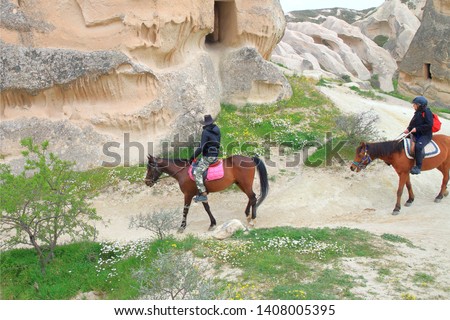 The photo was taken in Turkey in the Cappadocia region. In the picture are two young men walking horses on beautiful mountain paths.