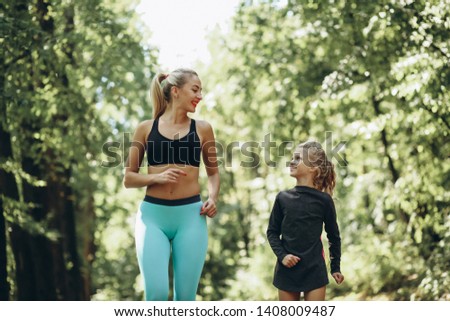 Woman with daughter jogging in park