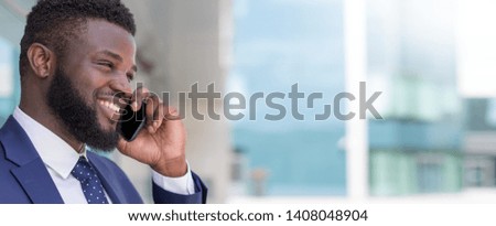 Portrait of smiling african businessman talking by phone outside with copy space