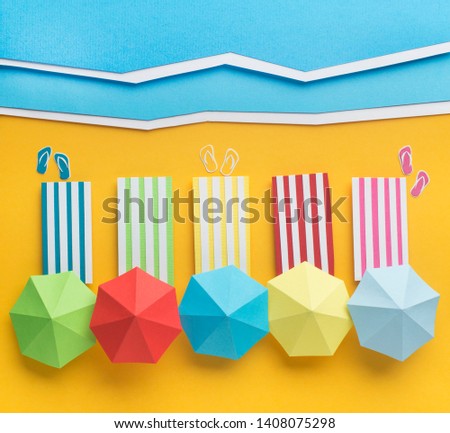 Vacation concept. Straight composition of sunbeds with different color umbrellas on sandy beach near the sea, paper photo, copy space
