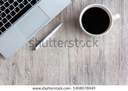 Office desk table with laptop, pen and cup of coffee. Top view of stylish workspace with copyspace. Flat lay.