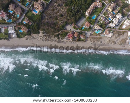 drone picture birds eye view of coast line with waves rolling in, half water half land